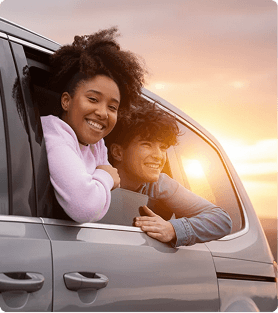 Crianças sorrindo apoiadas na janela de um carro